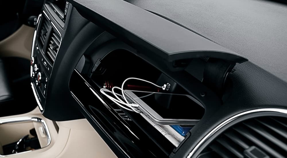 A tablet is charging in the glove box of a 2020 Dodge Grand Caravan.