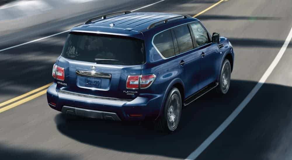 A blue 2020 Nissan Armada is shown driving from the rear at a higher angle.