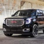 A black 2020 GMC Yukon Denali is parked in front of a concrete wall after winning the 2020 GMC Yukon vs 2020 Ford Expedition comparison.