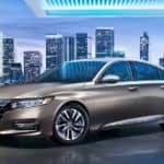 A tan 2020 Honda Accord is parked in front of a city at night after winning the 2020 Honda Accord vs 2020 Toyota Camry comparison.