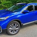 A blue 2020 Honda CR-V is shown at a front angle in front of trees.