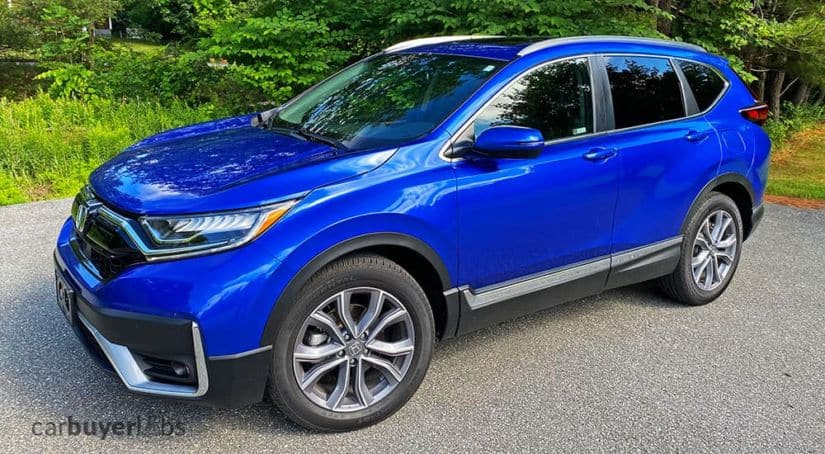 A blue 2020 Honda CR-V is shown at a front angle in front of trees.