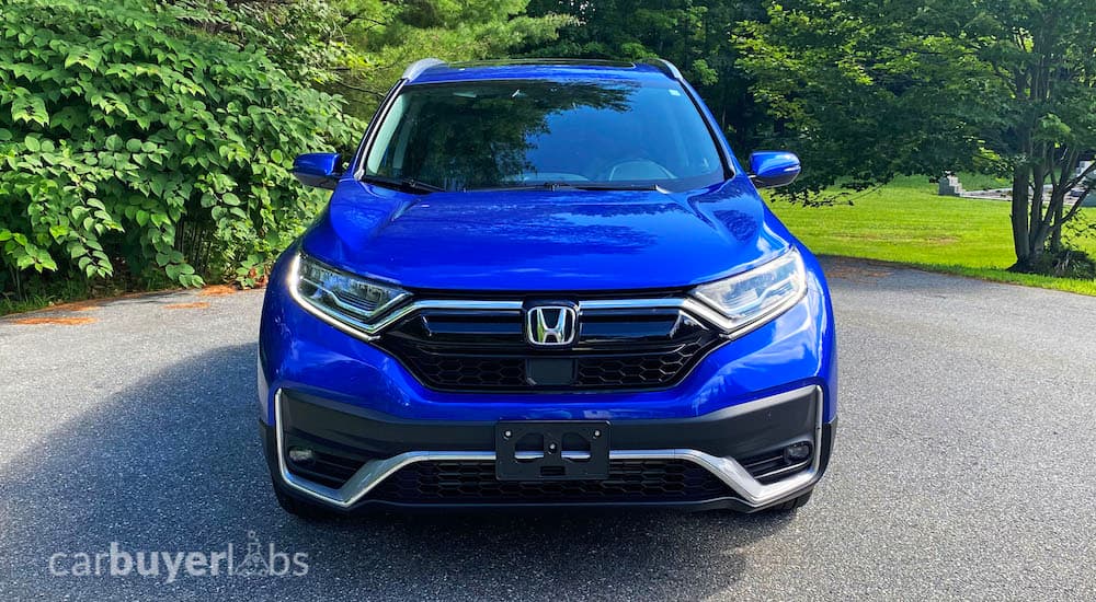 A blue 2020 Honda CR-V is shown from the front in front of a bush.