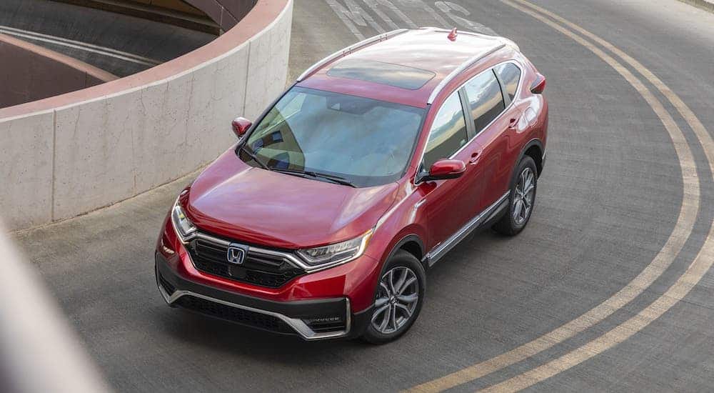 A red 2020 Honda CR-V Hybrid is shown from above getting on a highway.