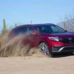 A red 2020 Honda CR-V Hybrid is kicking up sand in the desert.