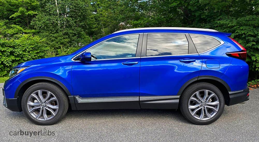 A blue 2020 Honda CR-V is shown from the side in front of trees.