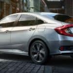 A silver 2020 Honda Civic Sedan Sport is parked on a city street.