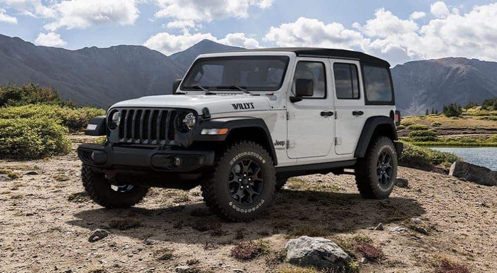 A white 2020 Jeep Wrangler Unlimited Willys edition is parked in front of a river.