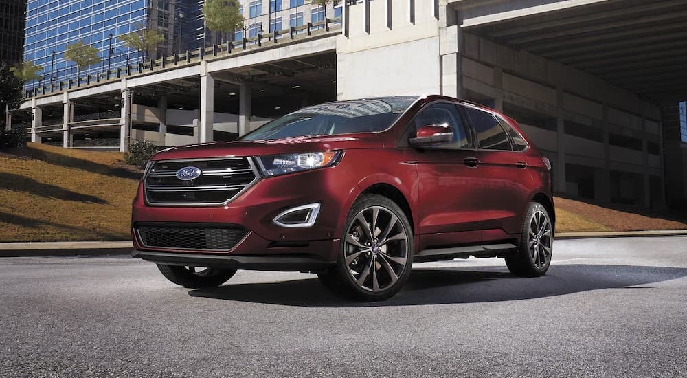 A red 2017 Ford Edge is parked in front of a bridge.