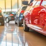 Various used cars are inside a dealership shown from a low angle.