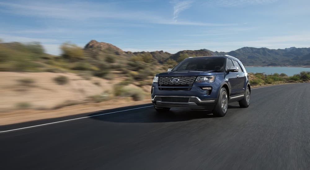 A blue 2018 used Ford Explorer is driving away from a lake.