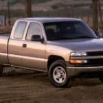 A silver 2002 Chevy Silverado is parked in front of a construction site.