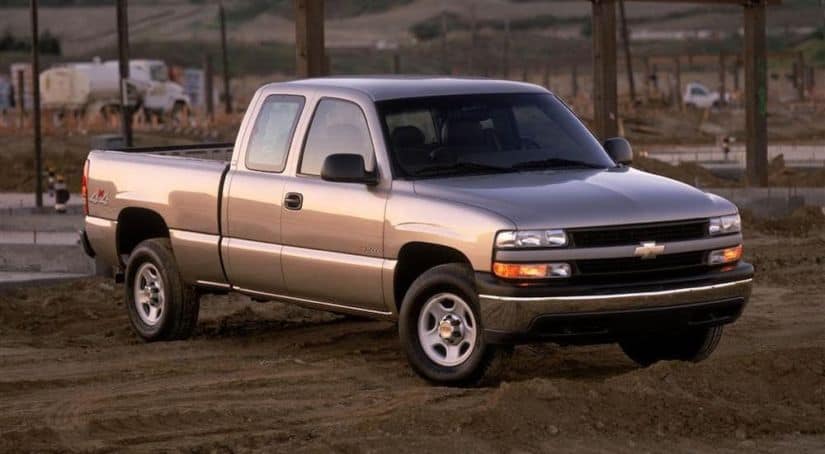 A silver 2002 Chevy Silverado is parked in front of a construction site.