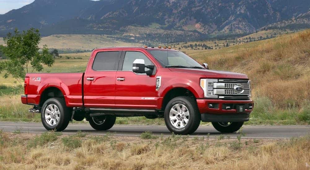 A red 2017 Ford F-250 Super Duty is parked in front of mountains.