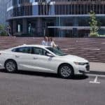 A white 2020 Chevy Malibu is parked in front of steps.