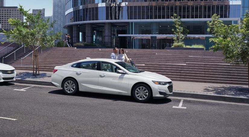 A white 2020 Chevy Malibu is parked in front of steps.