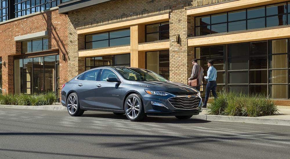 A gray 2020 Chevy Malibu is parked on a city street.