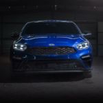 A blue 2020 Kia Forte is shown from the front in a dark garage.