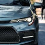 A closeup shows the grille of a gray 2020 Toyota Corolla.