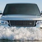 A silver 2020 Land Rover Ranger Rover is driving through deep water, shown from the front.