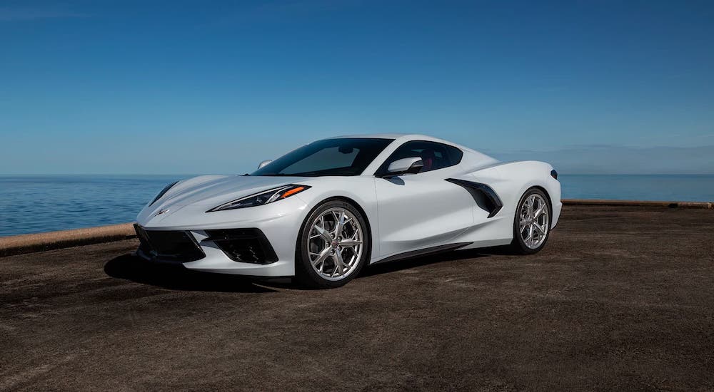 A white 2021 Chevy Corvette Stingray is parked in front of an ocean.