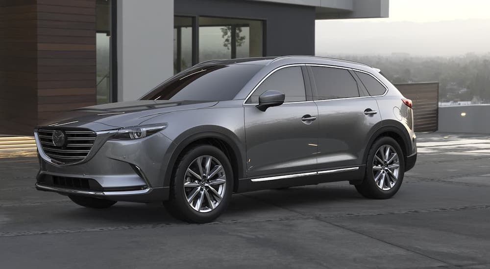 A gray 2020 Mazda CX-9 os parked in front a modern home.