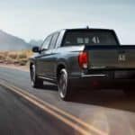 A gray 2019 Honda Ridgeline is driving away on a desert highway.