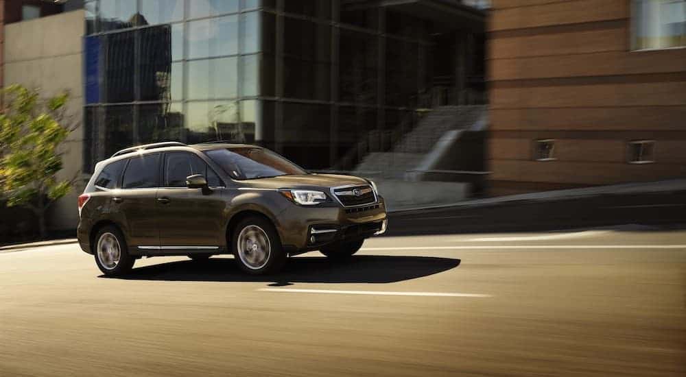 A grey 2017 Subaru Forester is driving on a city street.