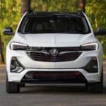 A white 2020 Buick Encore GX ST is shown on a tree-lined street from the front.