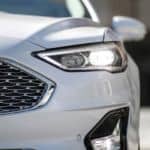 A closeup shows the front of a white 2020 Ford Fusion.