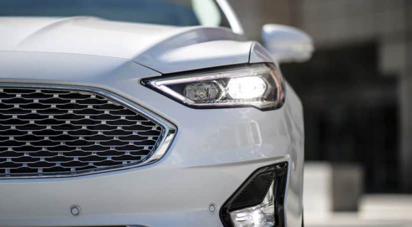 A closeup shows the front of a white 2020 Ford Fusion.