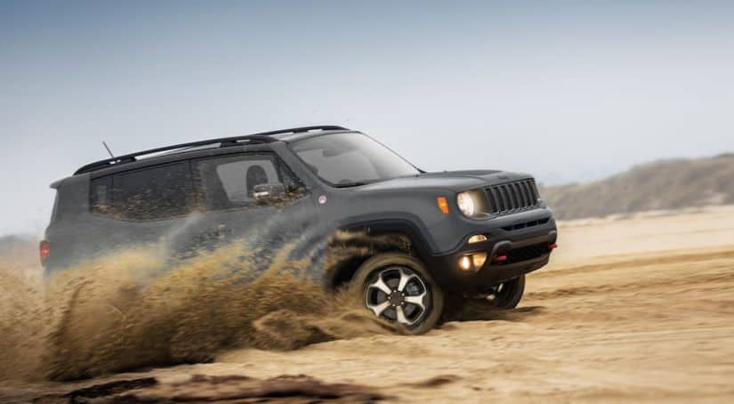 A grey 2020 Jeep Renegade is off-roading in the sand.