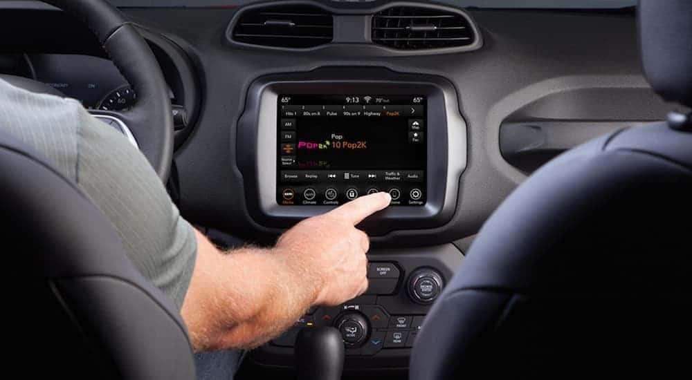 The touch screen in a 2020 Jeep Renegade is being used.