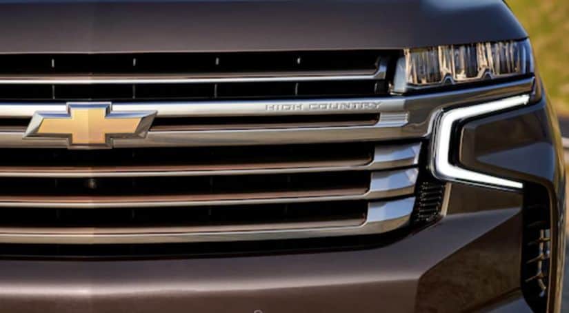 The grille of a grey 2021 Chevy Tahoe High Country is shown in closeup.
