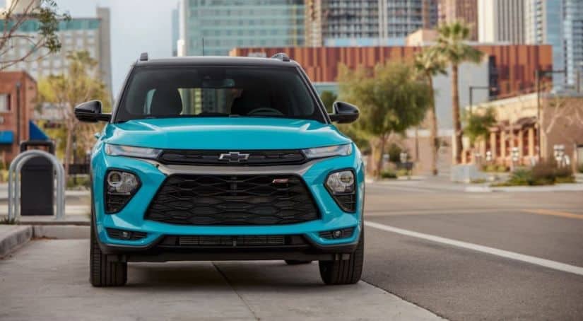 An aquamarine 2021 Chevy Trailblazer RS is parked on a city street and shown from the front.