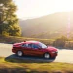 A red 2021 Honda Insight is driving on a mountain road.