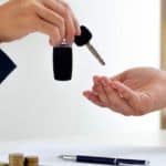 Car keys are being handed over after completing the loan paperwork.