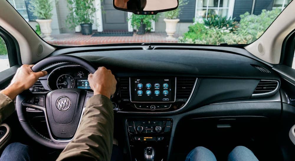 An interior view shows hands on the wheel in a 2020 Buick Encore.