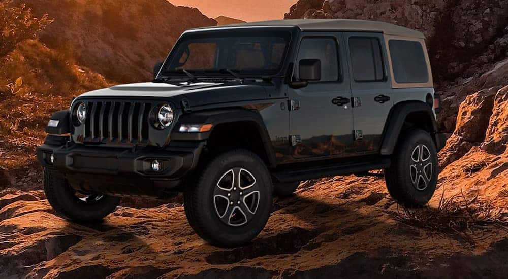 A Black and Tan edition 2020 Jeep Wrangler Unlimited is parked in front of desert mountains at sunset.