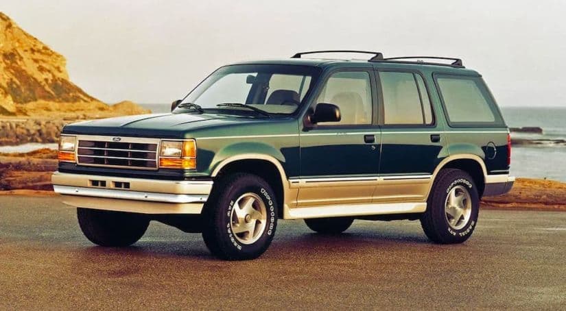 A dark green 1994 used Ford Explorer is parked on a beach.