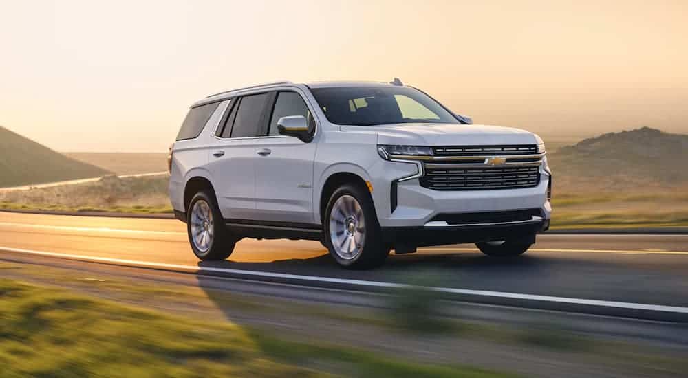A white 2021 Chevy Tahoe is driving down the road.
