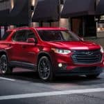 A red 2020 Chevy Traverse is parked in front of a restaurant.