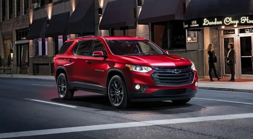 A red 2020 Chevy Traverse is parked in front of a restaurant.
