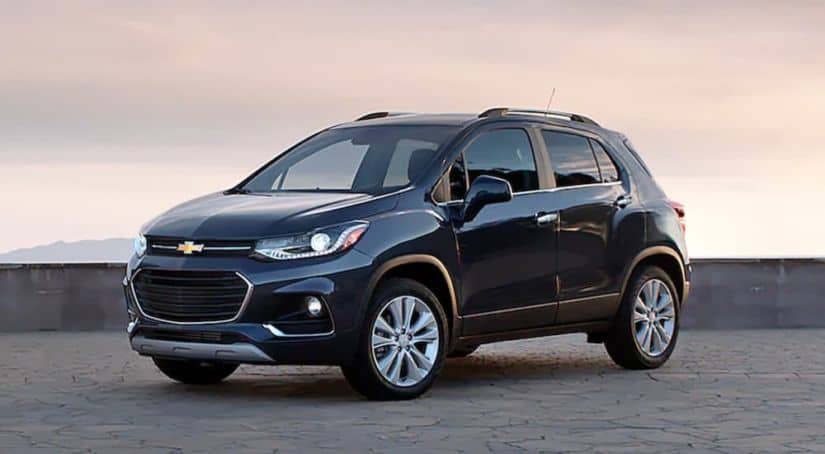 A dark blue 2020 Chevy Trax is parked on stone pavers at sunset after winning the 2020 Chevy Trax vs 2020 Mazda CX-3 comparison.