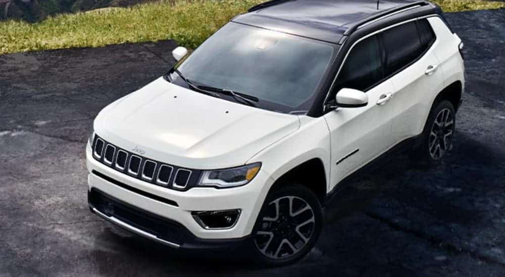 A white 2020 Jeep Compass is shown from a higher angle in front of grass after winning the 2020 Jeep Compass vs 2020 Mazda CX-5 comparison.