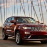 A burgundy 2020 Jeep Grand Cherokee is driving on a cable bridge.