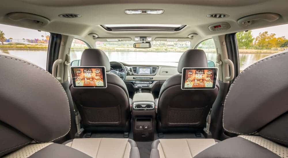 A 2021 Kia Sedona interior view is showing large headrest monitors.