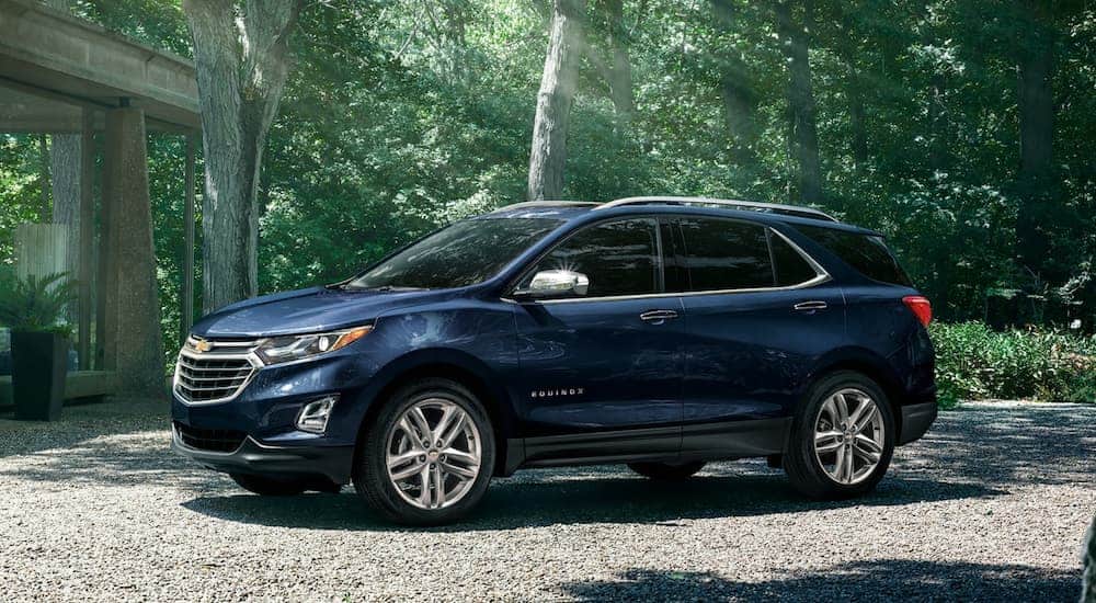 A blue 2020 Chevy Equinox is parked on a gravel driveway.