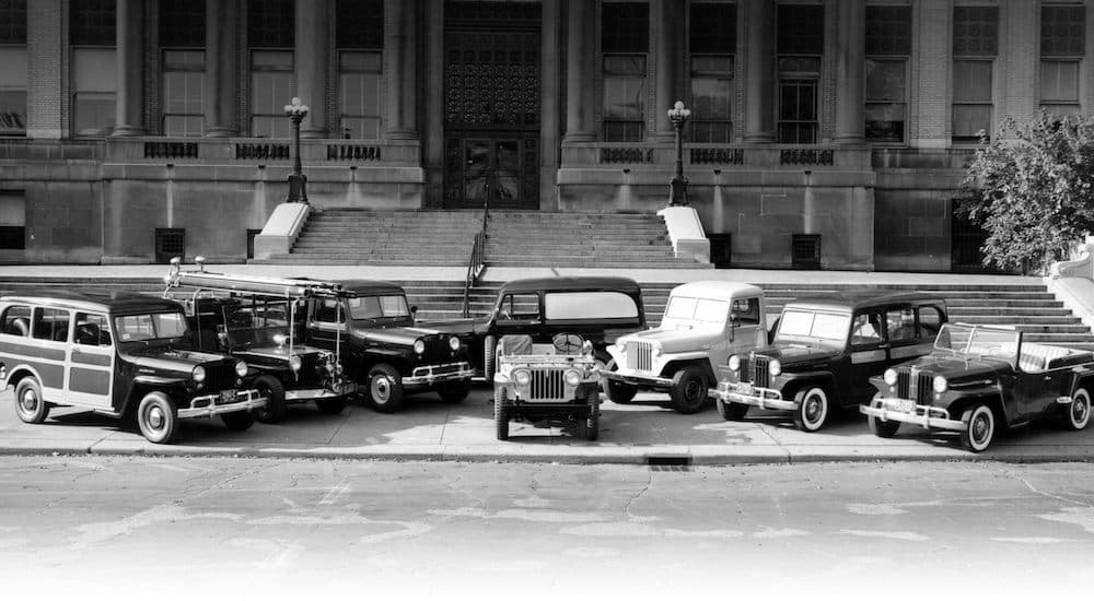A semi circle of old jeeps shown in black and white.