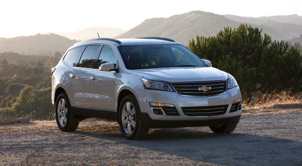 A white 2016 used Chevy Traverse is parked in front of mountain lookout.